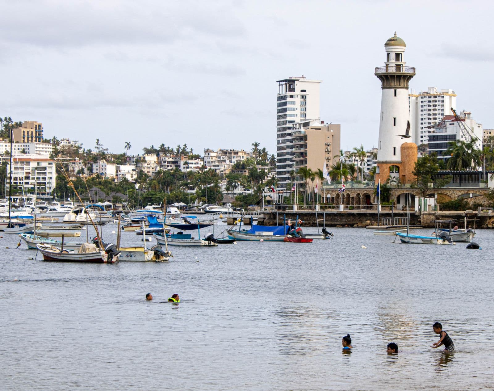 Bahía de Acapulco con nadadores y faro